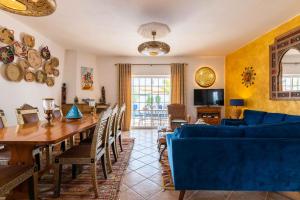 a living room with a table and a blue couch at Villa Oasis Galé - Luxury Villa with private pool, AC, free wifi, 5 min from the beach in Albufeira