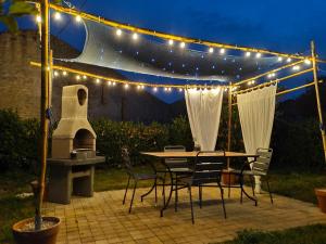 a patio with a table and chairs and lights at LE LOGIS DE LA PIERRE in Périgné