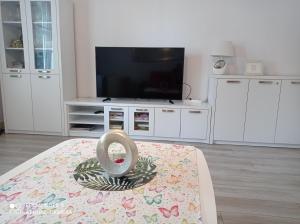 sala de estar con TV y mesa en Zorza Polarna, en Olsztyn