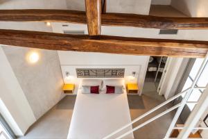 um quarto no sótão com uma cama e 2 almofadas em Domu Qirat - Authentic Rooms & Terraces em Tortolì