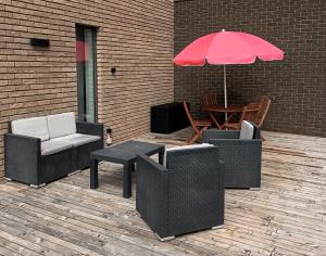 a patio with chairs and a table with an umbrella at Lu ptite cwane dol Lydie in Malmedy