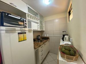 a kitchen with a refrigerator and a basket of fruit at Natal Plaza 604-Ponta Negra in Natal