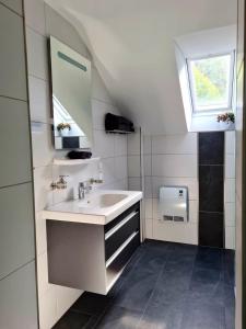 uma casa de banho branca com um lavatório e uma janela em Relax 2 em Bad Wildbad