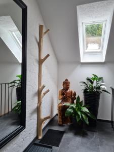 a mirror in a hallway with a statue and plants at Relax 2 in Bad Wildbad