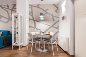 a dining room with a white table and chairs at Residenza 1955 in Matera