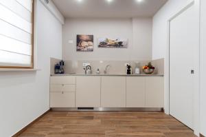 a kitchen with white cabinets and a sink at Residenza 1955 in Matera