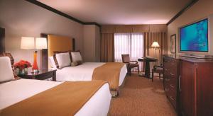 a hotel room with two beds and a flat screen tv at Ameristar Casino Hotel Council Bluffs in Council Bluffs