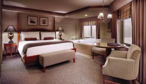 a bedroom with a bed and a bathroom with a tub at Ameristar Casino Hotel Council Bluffs in Council Bluffs