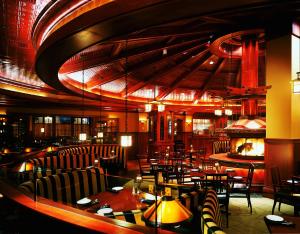 Ameristar Casino Hotel Council Bluffs في كاونسيل بلافز: مطعم بطاولات وكراسي ومدفأة