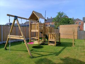 um parque infantil de madeira com um escorrega num quintal em Moodraz vakantiehuis centrum Peer em Peer