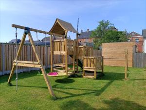 a wooden playground with a slide in a yard at Moodraz vakantiehuis centrum Peer in Peer
