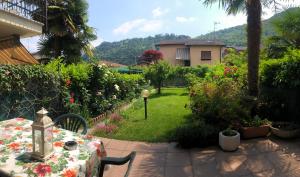 a table and chairs in a garden with a house at Casa Tiziana in Lavena Ponte Tresa