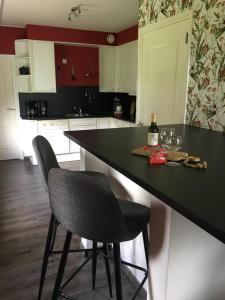 een keuken met een zwart aanrecht en 2 stoelen bij Op de Lutter Esch in Lutten