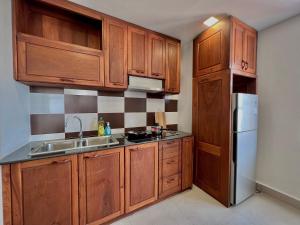 a kitchen with wooden cabinets and a stainless steel refrigerator at WH Bassac Residence in Phnom Penh