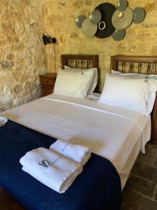 a bedroom with a large white bed with towels on it at Villa Danae in Meganisi