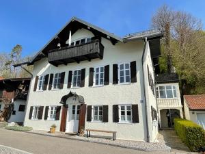 una casa blanca con un banco delante en Haus am Weinberg, 83370 Seeon Oberbayern, en Seeon-Seebruck