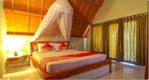 a bedroom with a bed with a canopy at Yoland Guesthouse in Gili Islands