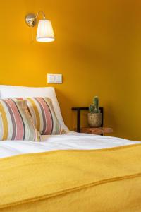 a bedroom with two beds with yellow walls at Boutique Hotel Enkhuizen in Enkhuizen