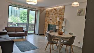 a living room with a table and chairs and a couch at Anastasia apartments in Buşteni