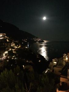 a full moon rising over the water at night at Hotel Posa Posa in Positano