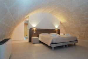 a bedroom with a bed and a brick wall at I Lamioni - Suite & accommodation in Matera