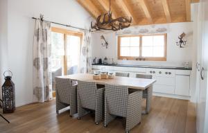 a kitchen with a table and chairs in a room at Central holiday flat Scalottas Lenzerheide in Lenzerheide
