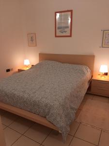 um quarto com uma cama e duas mesas de cabeceira com candeeiros em Casa Alberoni em Ravenna