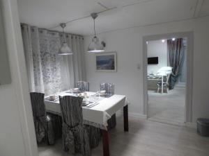 蒂勒的住宿－Suite EUGENIE piscine MAISON BLANCHE TULLE，一间配备有白色桌椅的用餐室