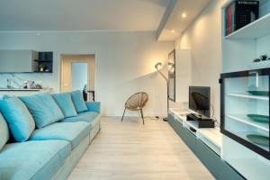 un salon avec un canapé bleu et une télévision dans l'établissement CaseOspitali - Casa Janas, elegante trilocale per 5 in zona centrale, à Milan