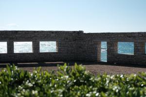 a brick wall with windows in front of the ocean at Banfi's villa on the sea in Bisceglie