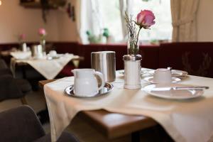 a table with a vase with a flower on it at Gästehaus Reicher in Afritz