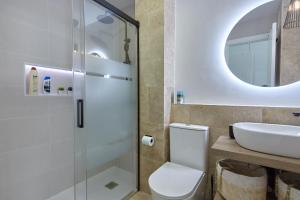 a bathroom with a toilet and a sink and a mirror at APTARTAMENTO DOÑANA RECIEN REFORMADO Parking gratis in Sanlúcar de Barrameda +63 photos
