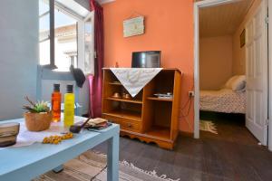 um quarto com paredes cor de laranja e um quarto com uma mesa em Corfu Town Central Apartment em Corfu Town