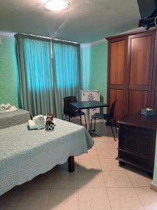 a bedroom with a bed and a table and a table at La Villa Del Patrizio in Ostia Antica
