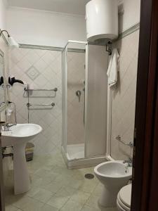 a bathroom with a shower and a toilet and a sink at La Villa Del Patrizio in Ostia Antica