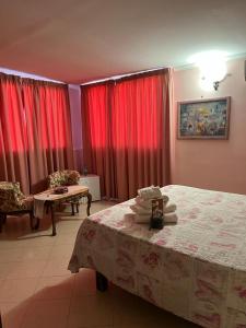 1 dormitorio con cortinas rojas, 1 cama y 1 mesa en La Villa Del Patrizio, en Ostia Antica