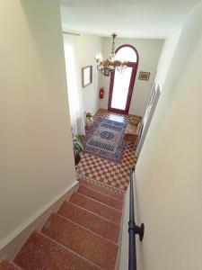 a hallway with stairs with a chandelier and a window at Ca' D'Agostino in Battaglia Terme