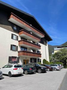 a building with cars parked in a parking lot at Vidaoro Studio Flat in Zell am See
