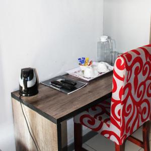 a red and white chair sitting next to a wooden table at Platinum Hotel in Gaborone