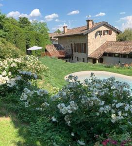 un jardín con flores y una casa de fondo en Al vecchio fienile en Fagagna