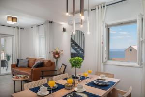 a living room with a table and chairs and a couch at Villa Mirta in Bol