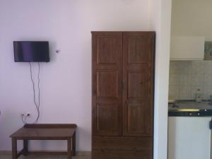 een deur in een kamer met een tafel en een keuken bij Giannatos' Studios - Makis in Póros