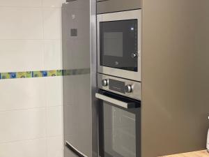 a microwave oven sitting inside of a kitchen at Oktheway Pedro Saco Street 2 in Sarria