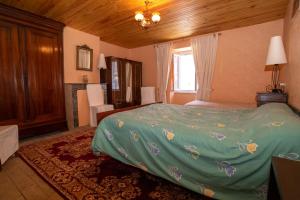 een slaapkamer met een bed met een groen dekbed bij Gite les Cerisiers dans les Gorges du Tarn in La Cresse