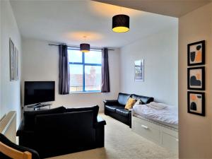 a living room with a couch and a tv at Central Apartments - Spacious 2 Beds in Swindon