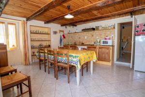 een keuken met een tafel en stoelen en een koelkast bij Gite les Cerisiers dans les Gorges du Tarn in La Cresse