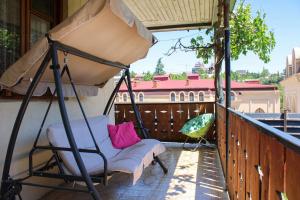 a porch with a chair and an umbrella on a balcony at Nino's Guest House in Tbilisi City