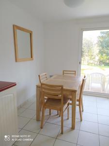 une table et des chaises dans une cuisine avec une fenêtre dans l'établissement Location appartement meublé bord de mer, à Fouesnant