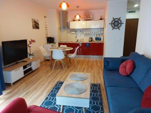 a living room with a blue couch and a table at 9 APARTAMENT VILLA NORD - parking in Jastrzębia Góra