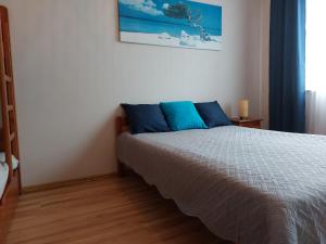 a bedroom with a bed with blue pillows at 9 APARTAMENT VILLA NORD - parking in Jastrzębia Góra